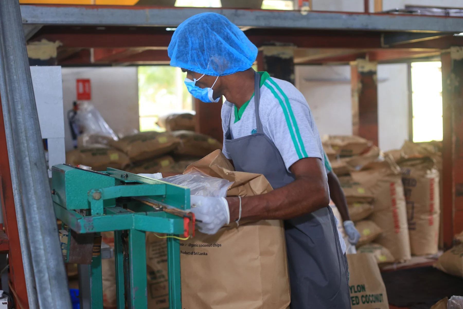 A team member sealing a bag of Nutrikokos coconut products